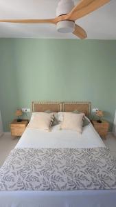 a bedroom with a bed with a ceiling fan at HOLIDAYS MENORCA Cala Galdana in Cala Galdana