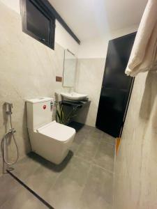 a bathroom with a toilet and a sink at Rainforest Mountain Escape - Lankagama in Deniyaya