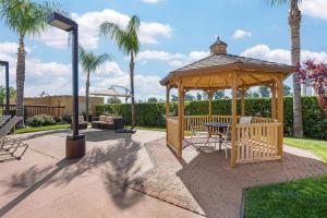 a wooden gazebo in a park with palm trees at Best Western Plus Fresno Airport Hotel in Fresno