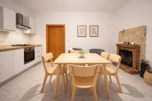 a kitchen and dining room with a wooden table and chairs at Salerno casa con jacuzzi privata e cinema in Salerno +17 photos