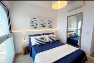a bedroom with a blue bed and a mirror at Casa Pomonte in Pomonte