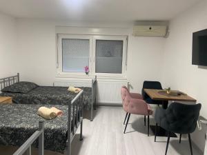a bedroom with a bed and a table and chairs at King Rooms in Novi Kneževac