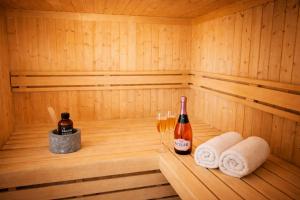 a sauna with two bottles and two glasses of wine at Reethus-am-Hafen Reetdachhaus Hafenblick mit Garten und Blick aufs Wasser in Rankwitz
