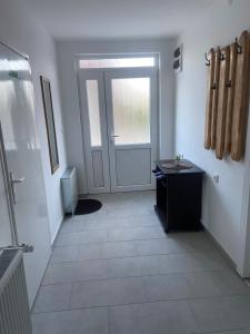 a hallway with a door and a tiled floor at King Rooms in Novi Kneževac +1 photo