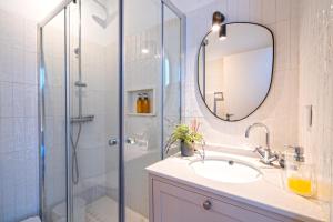 a bathroom with a sink and a shower with a mirror at Pátio da Achada View Apartment in Funchal +56 photos