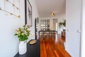 a living room with a vase of flowers on a table at Pátio da Achada View Apartment in Funchal