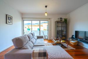a living room with a couch and a tv at Pátio da Achada View Apartment in Funchal