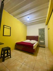 a bedroom with a bed in a yellow room at PTS Homestay Syariah in Bandung +7 photos
