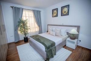 a bedroom with a large white bed and a window at The Prestige Hub Residences in Eldoret