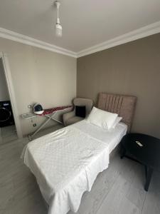 a bedroom with a large bed and a chair at Konyaaltı gürsu denize sıfır sahilde full eşyalı lüks daire in Antalya