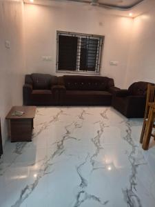a living room with a couch and a marble floor at SUMATHY GIRLS HOSTEl in Chennai