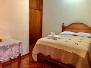 a bedroom with a bed and a table with towels on it at Echevarria Oxapampa in Oxapampa +4 photos