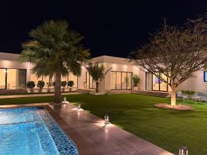 a house with a swimming pool in a yard at night at Quiet House villa in Hatta