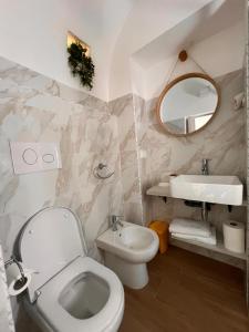 a bathroom with a toilet and a sink and a mirror at Casa Vacanza Pietre & Cielo in Ceglie Messapica +29 photos