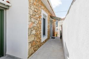 an alley between two buildings with a window at Angie's Central Apartment in Pappadhiánika