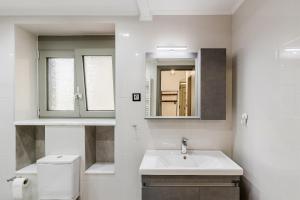a bathroom with a sink and a toilet and a mirror at Angie's Central Apartment in Pappadhiánika +25 photos