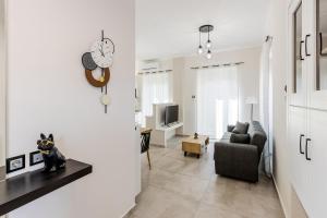 a living room with a couch and a clock on the wall at Angie's Central Apartment in Pappadhiánika
