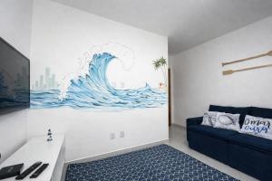 a living room with a wave mural on the wall at Flats Temáticos - By Temporada Expert - Conforto e Climatizado in Feira de Santana