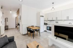a kitchen and living room with a table and a couch at Angie's Central Apartment in Pappadhiánika