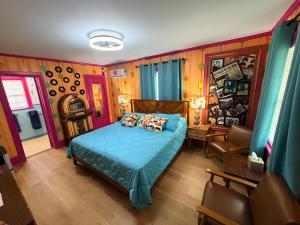 a bedroom with a blue bed and a chair at Historic Ziegler Inn and Suites with Whimsical Themed Rooms in New Bern