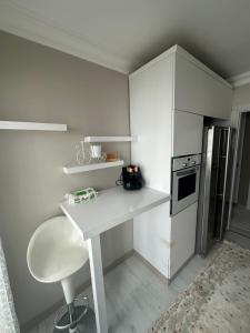 a white kitchen with a desk and a refrigerator at Konyaaltı gürsu denize sıfır sahilde full eşyalı lüks daire in Antalya
