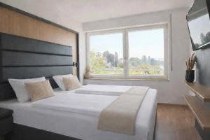 a bedroom with a large bed with a large window at DaSalvatore in Wasserburg