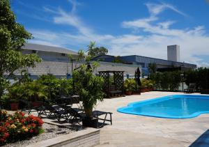 a swimming pool in front of a building at Favorita Golden Hotel e Eventos in São José