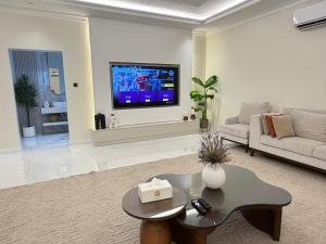 a living room with a tv and a couch and a table at Quiet House villa in Hatta