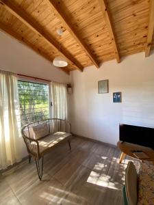 a living room with a bench and a piano at HastaLaRaíz-LosReartes in Los Reartes