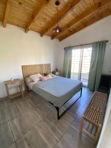 a bedroom with a bed and a wooden ceiling at HastaLaRaíz-LosReartes in Los Reartes