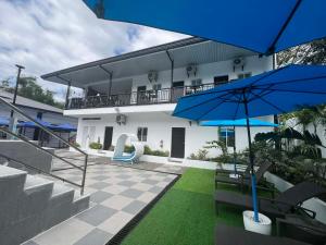 a house with a patio with blue umbrellas at Villa Trajano Resort in San Antonio