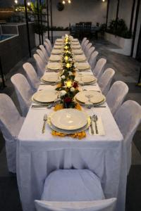 a long table with white chairs and plates on it at Villa Trajano Resort in San Antonio +58 photos