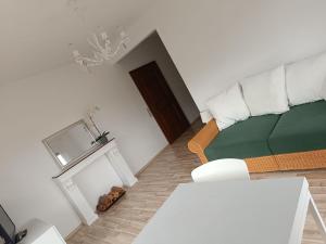 a living room with a green couch and a table at Haus Christof in Ledenitzen