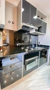 a kitchen with a black counter top at Loft sua morada in Capão da Canoa