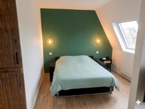 a bedroom with a green wall and a bed at Le #7 - Centre ville - Parking privé - Balcon in Saint-Omer