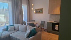 a living room with a couch and a table with chairs at New delux appartement in Keila +4 photos