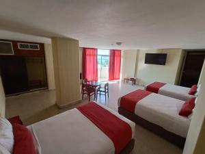 a hotel room with two beds and a table at Hotel Royalty in Veracruz