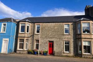 two houses with a red door on a street at Glen Oirig in Hunters Quay