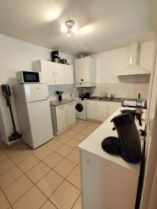 a kitchen with white cabinets and a white refrigerator at Appart 2 Ch Bollezeele in Bollezeele