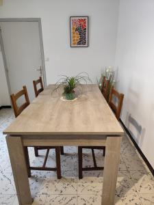 a wooden table with chairs in a room at Appart 2 Ch Bollezeele in Bollezeele
