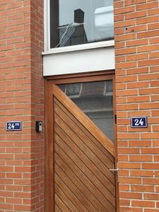 a wooden garage door in a brick building at Appart 2 Ch Bollezeele in Bollezeele +1 photo