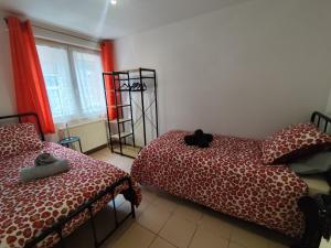 a bedroom with two twin beds and a window at Appart 2 Ch Bollezeele in Bollezeele
