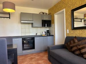 a living room with a couch and a kitchen at Villa Waldblick Baabe in Baabe