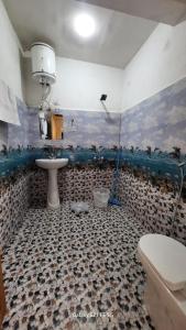 a bathroom with a sink and a toilet at tirthan horizon homestay in Banjār