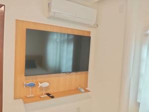 a flat screen tv hanging on a wall at Casa da Dinda 103 in Rio das Ostras