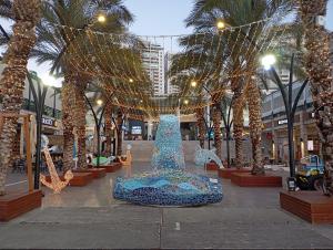 a large blue sculpture in a mall with christmas lights at Marina Breeze in Ashkelon