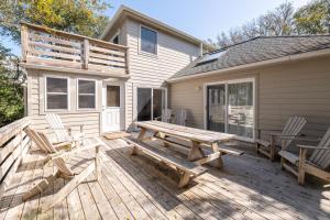a wooden deck with a picnic table and chairs at Sparrow's Rest - Duck, Sanderling, 350 Yards to the Beach, Community Pool, YR Flex Stays in Duck