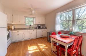 a kitchen with a red table and red chairs in it at Sparrow's Rest - Duck, Sanderling, 350 Yards to the Beach, Community Pool, YR Flex Stays in Duck
