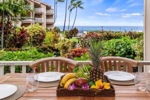a wooden table with a basket of fruit on it at Sea Village 2106 in Kailua-Kona