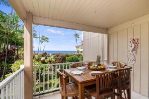 a table and chairs on a balcony with a view of the ocean at Sea Village 2106 in Kailua-Kona